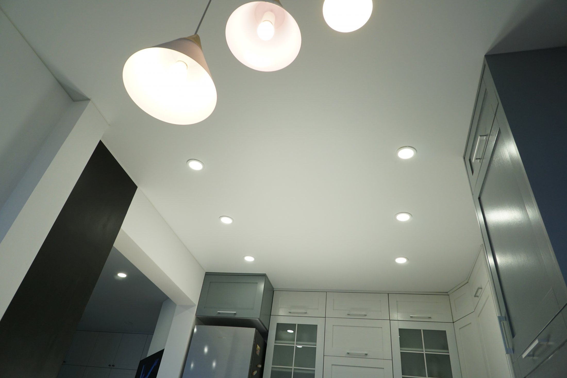 Тканевый потолок на кухне со светильниками и люстрами